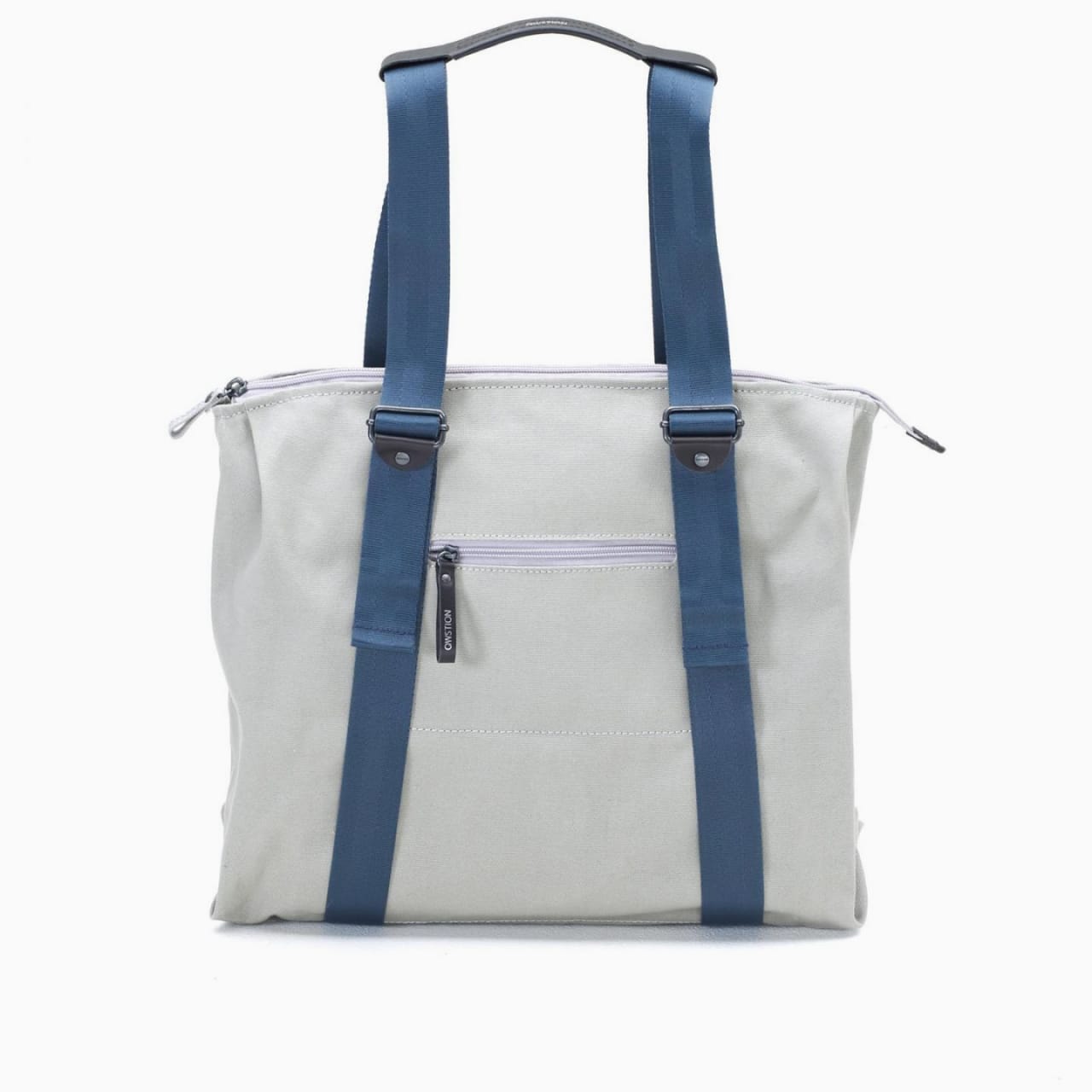 Front of satchel with blue canvas body, black straps and handle, drawstring top, and front zipper pouch.